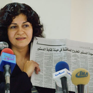 Yanar Mohammed, founder of the Women's Freedom Organization in Iraq, speaks to reporters while holding a newspaper copy of Iraq's new constitution,  Baghdad, July 28, 2005. 
