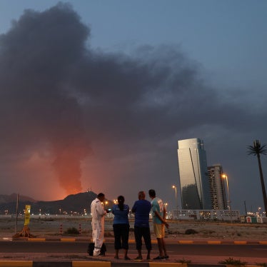 Foreign workers watch a plume of black smoke following an explosion in the Fujairah industrial zone in the United Arab Emirates, March 3, 2026. 