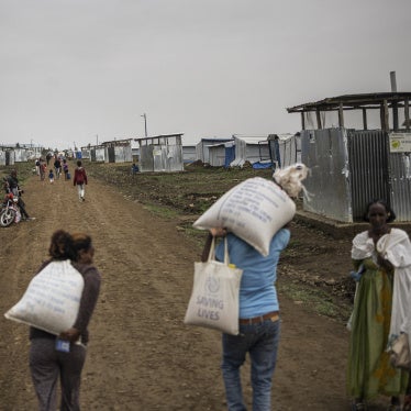Internally displaced people carry food parcels during a distribution at Seba Care displaced persons camp in Mekelle, Tigray region, Ethiopia, July 19, 2024.
