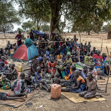 Families gather under a tree at an informal site where displaced people, many from neighboring Jongeli state, have assembled without assistance or shelter at Yolakot informal camp near Mingkaman, Lakes state on February 14, 2026. 