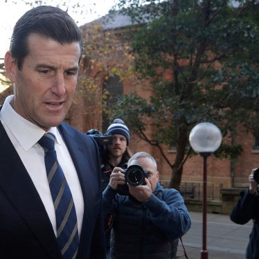 a man arrives at a courthouse followed by reporters