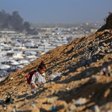 A girl climbs a hilltop against the backdrop of smoke rising from the Gath shelter, that houses displaced Palestinians, after an Israeli air strike in Khan Yunis, southern Gaza Strip on January 31, 2026. 