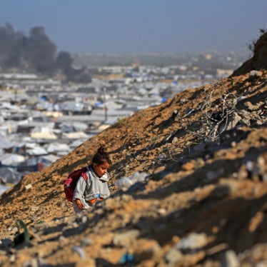 A girl climbs a hilltop against the backdrop of smoke rising from the Gath shelter, that houses displaced Palestinians, after an Israeli air strike in Khan Yunis, southern Gaza Strip on January 31, 2026. 