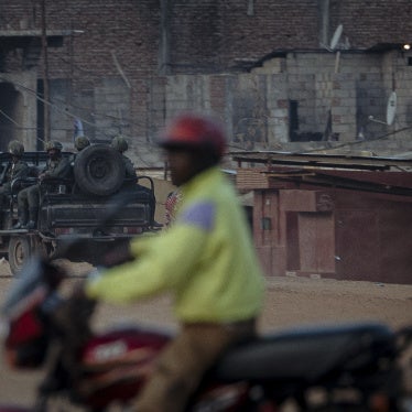 A car of armed soldiers patrols a street