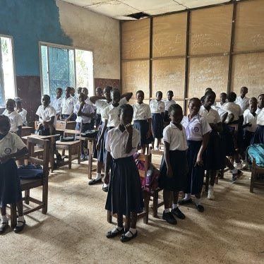 Students standing at their desks in a classroom