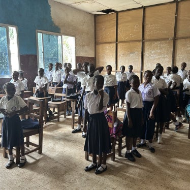 Students standing at their desks in a classroom