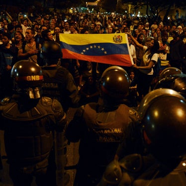 Anti-government students show a national flag to a National Guard barricade during a protest in Caracas, Venezuela, on February 16, 2014. 