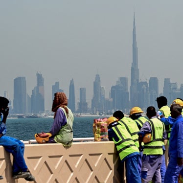 Workers sit on a wall against the backdrop of the city skyline, Dubai, UAE, March 11, 2026.