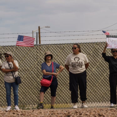 Protesters opposing mass deportations by ICE hold signs during a demonstration held outside of Fort Bliss
