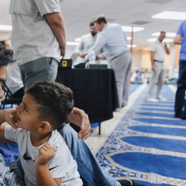 Naseer Ahmad Paktiawal holds Abubakar Paktiawal, son of his brother Mohammad Nazeer Paktiawal, who died in ICE custody, at the Abu Hanifa Mosque in Richardson, Texas, U.S. June 4, 2026.