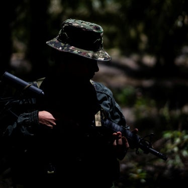 An unidentifiable child soldier holding a gun