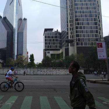 One of the government barriers surrounding the site bears the message: "130,000 disappeared."
