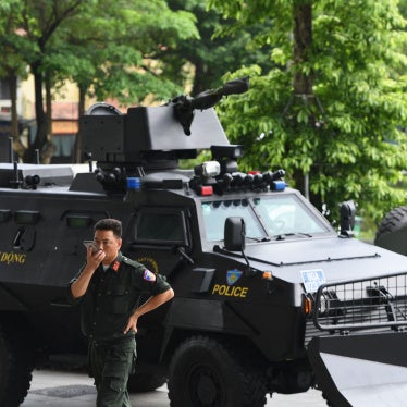 A Vietnamese policeman stands besides an armored vehicle at an exhibition of police equipment in Hanoi, July 20, 2022.