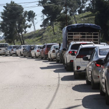 Palestinians wait to cross at the Israeli Awarta military checkpoint on March 23, 2025, south of Nablus in the West Bank.