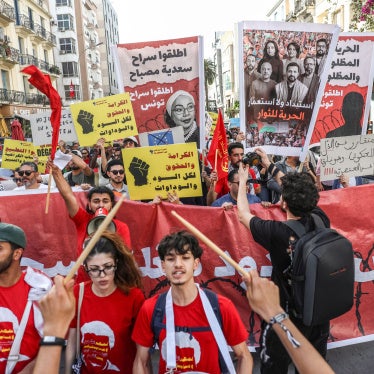 Tunisians hold up placards during a march organized by the Campaign Against the Criminalization of Civil Work to protest racism in Tunis, April 11, 2026