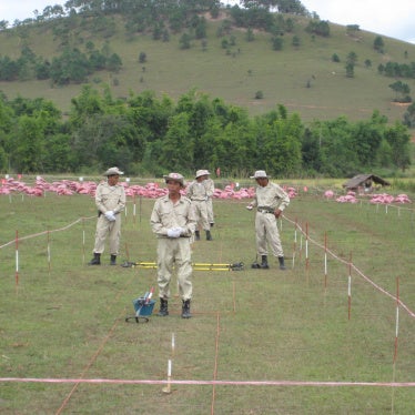 Red sandbags cover unexploded submunitions awaiting destruction near a school in Xiang Khouang Province, Laos