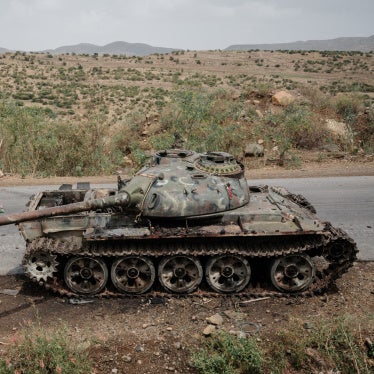 Farmers walk past an alleged Eritrean army tank abandoned in Dansa, southwest of Mekele in Tigray region, Ethiopia, June 20, 2021. 