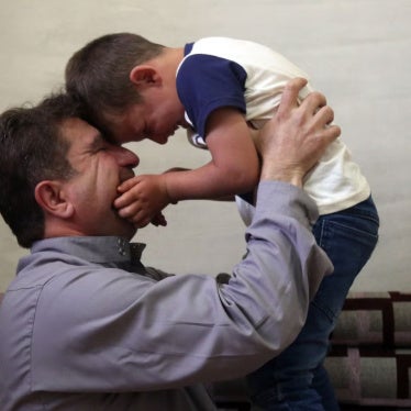 Ibrahim, a 5-year-old boy with autism, is held by his father in Idlib, Syria, June 2022.