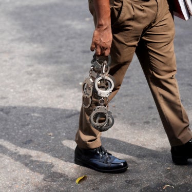 A police officer holds handcuffs as he walks inside a court premises in Colombo, Sri Lanka, August 6, 2026.