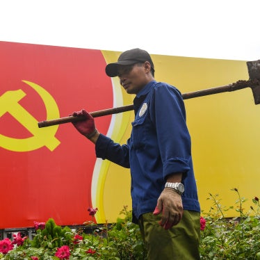 A worker walks past a sign with the Vietnamese Communist Party flag in Hanoi