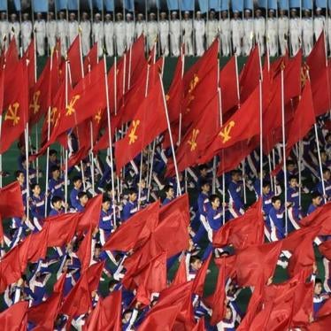 North Koreans hold Workers' Party flags during a mass performance in Pyongyang on July 26, 2013. 