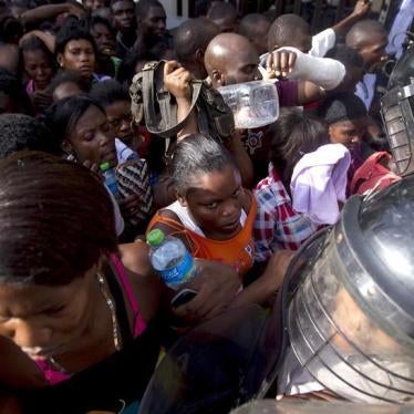 Haitians face police while waiting outside the Ministry of Interior and Police to register in Santo Domingo, June 16, 2015.