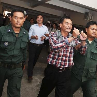 Supporters of the Cambodia National Rescue Party (CNRP) are escorted by Cambodian police officers at the Phnom Penh Municipal Court on July 21, 2015.