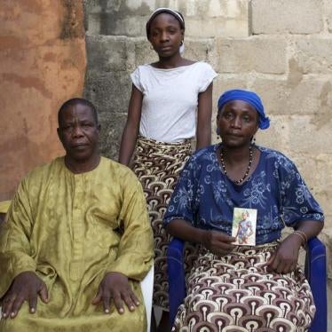 Chiroma Maina holds a picture of her abducted daughter Comfort Amos, next to her husband Jonah and her daughter Helen, at their home in Maiduguri, Nigeria on May 21, 2014.