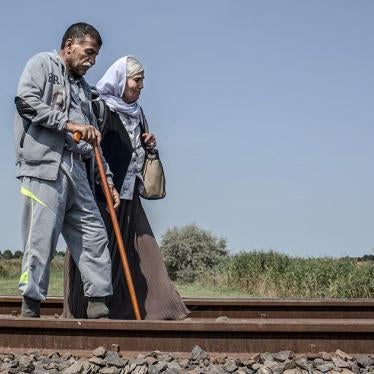 Hassan and his wife Sheri, both Iraqi Kurds, walk along train tracks in Röszke, Hungary after crossing the border with Serbia. September 3, 2015.