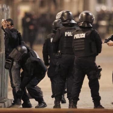 French police stop and search a local resident during an operation in Saint-Denis, France.