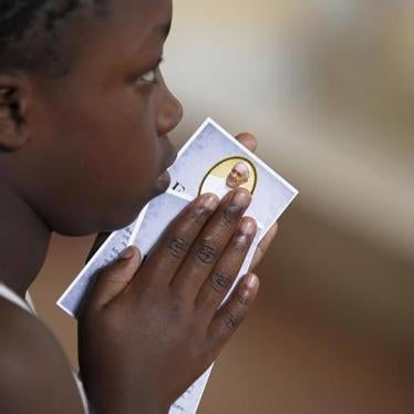 A child holds a prayer paper with the photo of Pope Francis during a special mass at St. Joseph the Worker Catholic Parish within Kangemi, a slum that is home to 650,000 people in Kenya's capital Nairobi, on November 22, 2015. 