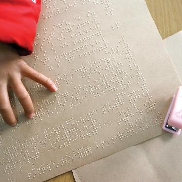 A blind girl reads Braille text in her class at the Shanghai School for the Blind in Shanghai.