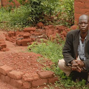 Jean Baptiste Nguondija, a resident of Ngbada, Central African Republic, by the grave of his 10 year-old daughter Nathana Poura. Nguondija has lost 5 children since the conflict began in 2013. 