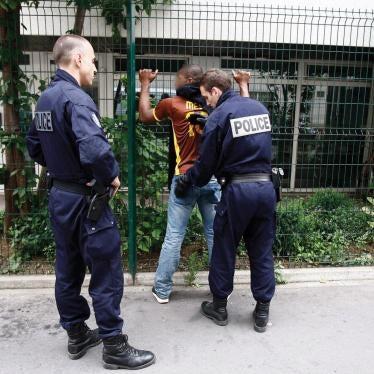 Police officers perform an identity check and body pat-down of a young man in Paris, France.