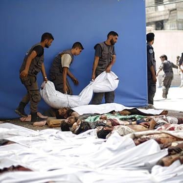 Syrian emergency personnel gather around dead bodies wrapped in shrouds following air strikes by Syrian government forces on a marketplace in the rebel-held area of Douma, east of the capital Damascus, Syria on August 16, 2015. 