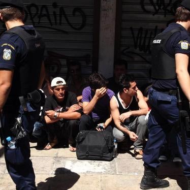 Police detain individuals assumed to be migrants in central Athens, on Sunday, August 5, 2012.