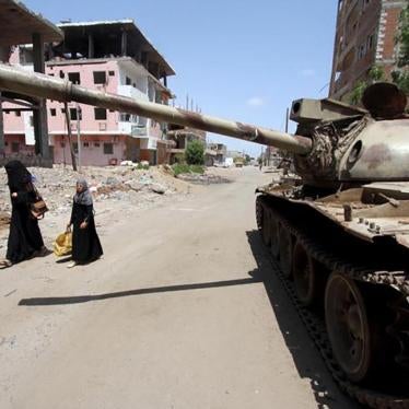 A woman and a girl walk past a broken-down tank on a street in Yemen's southern port city of Aden on September 27, 2015. 