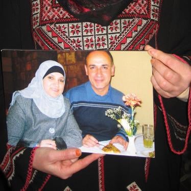 Manal Alsaafin holds a photograph of her and her husband, Abdullah, whom Israeli authorities have prevented from returning to his home in the West Bank since 2009 on the basis that they have “registered” him as a resident of the Gaza Strip.