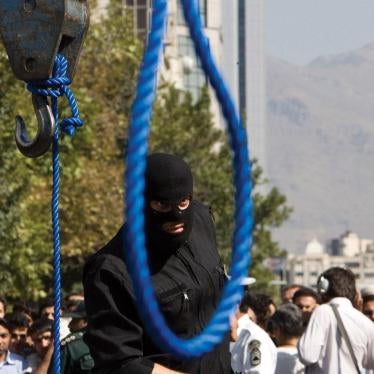 A masked Iranian policeman preparing for the public hanging of a convicted criminal in Tehran on August 2, 2007.