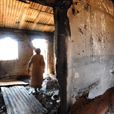 A woman walks through a house that was burned during the January 19, 2010 attack on Kuru Karama, Plateau State, which left more than 170 Muslims dead. 