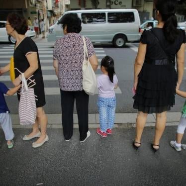 上海闹区，妇女们牵着孩子准备过马路，2014年9月12日。
