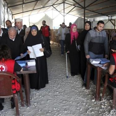 叙利亚难民在黎巴嫩北部特利波里排队领取联合国难民署（UNHCR）发放的冬季救济物资，2015年11月18日。