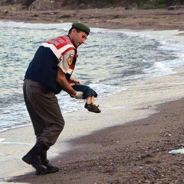A man carries the body of a dead Syrian boy who died at sea. 