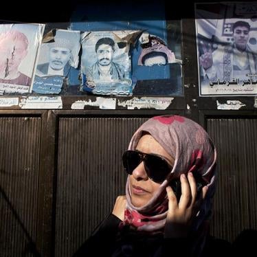 Sarah Jamal Ahmed, a 24-year-old sociologist who was one of the activists during the 2011 uprising in Sanaa, stands by posters of dead protesters posted in the streets.