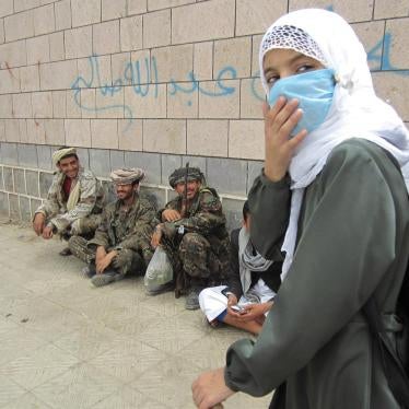 A girl student leaves al-Furadh School at the end of the day. Soldiers relax and chew qat outside the school walls. They lived in third-floor classrooms for several months, students and teachers said.