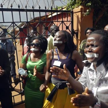 Employees of the Daily Monitor newspaper with their mouths taped shut, sing slogans during a protest against the closure of their premises by the Uganda government, outside their offices in the capital Kampala May 20, 2013. 