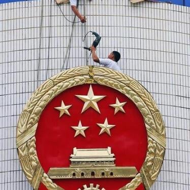 Workers fix the national emblem outside the provincial Supreme People's Court in Haikou, southern China's Hainan province, August 7, 2006. 