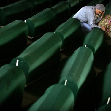 Two Bosnian Muslim women cry over a coffin July 10, 2005 with remains of their relative in a factory hall in Potocari where 610 victims of Srebrenica massacre wait for the funeral.