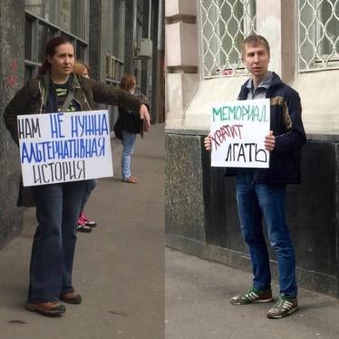 Two protesters outside the venue of an award ceremony with posters that read “We do not need alternative history” and “Memorial, stop lying”, April 28, 2016, Moscow. 