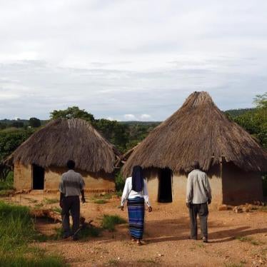 An HIV-positive 71-year-old man walks with caregivers during a visit by a home-based care team in the village of Nedwmba in the south of Zambia, February 23, 2015. 